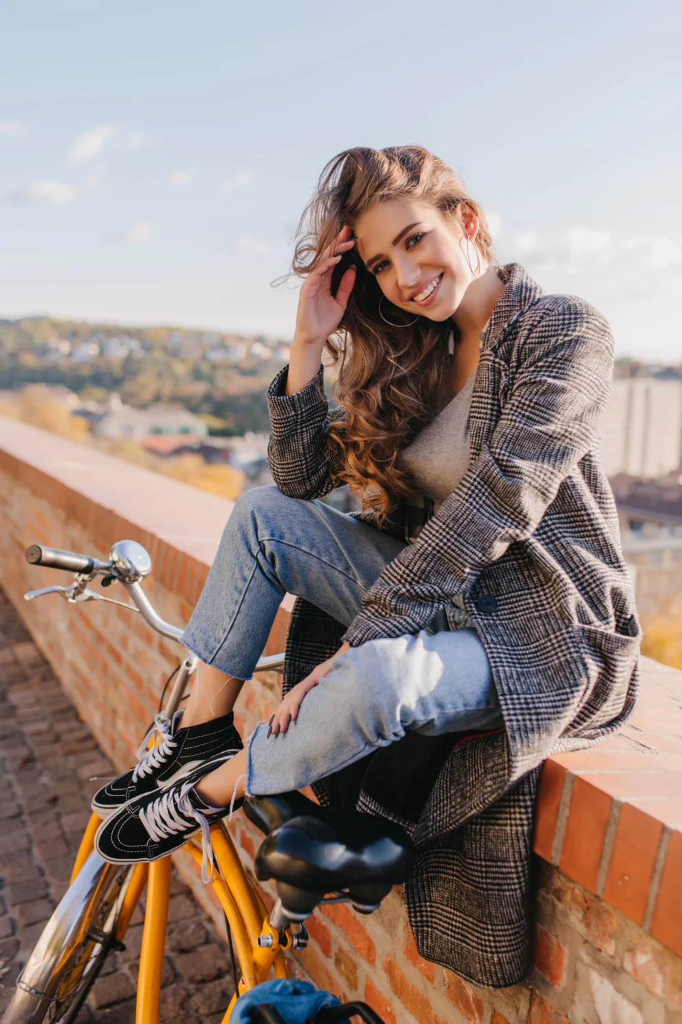 brown haired lady smiling while sitting in a bench
